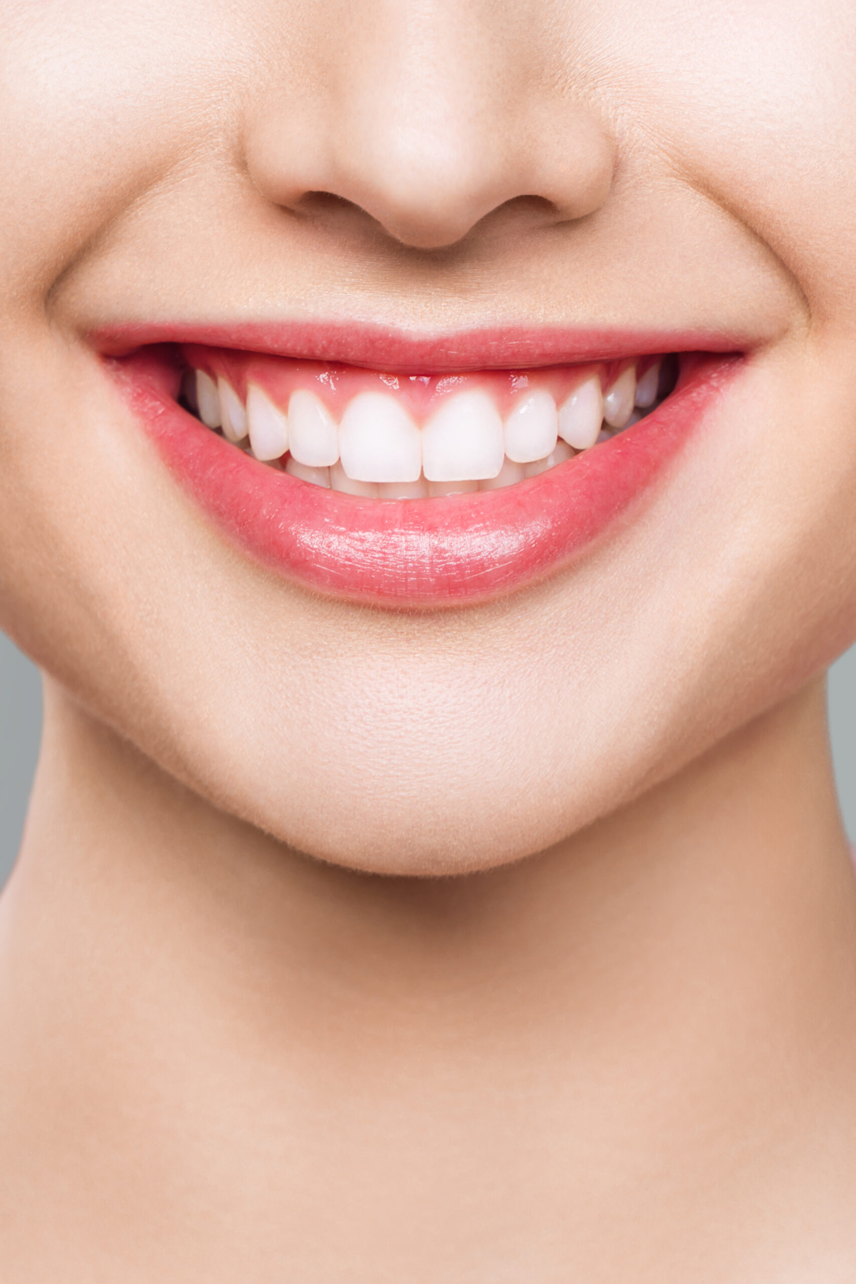 A vibrant closeup showcasing an incredibly bright smile adorned with immaculate teeth and soft, pink lips