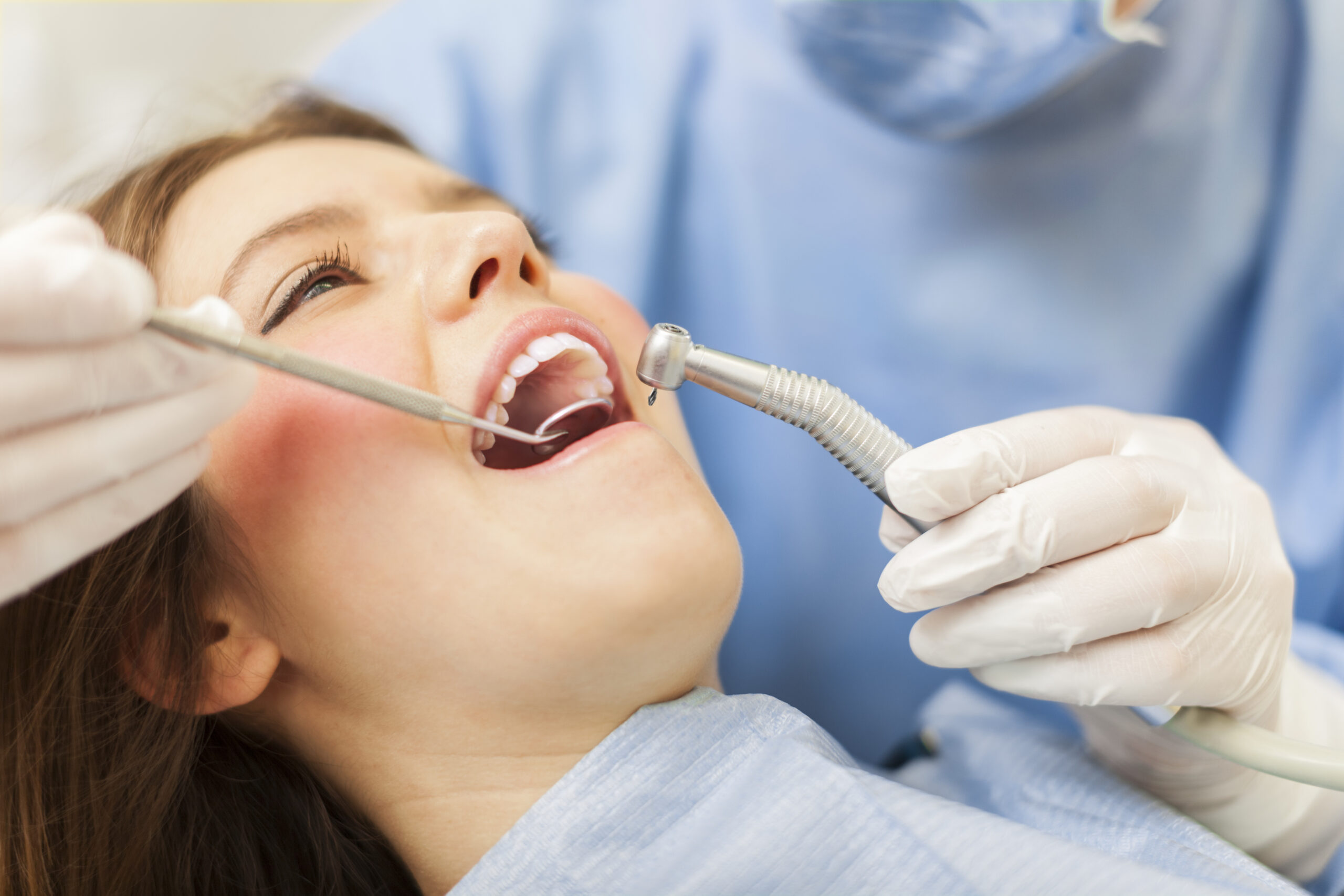 Dentist curing a female patient